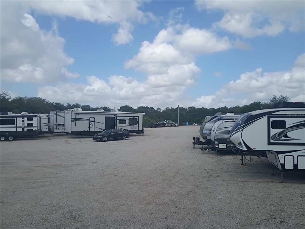 A gravel lot contains several parked recreational vehicles under a partly cloudy sky — 0 STATE ROAD 33 N, LAKELAND, FL