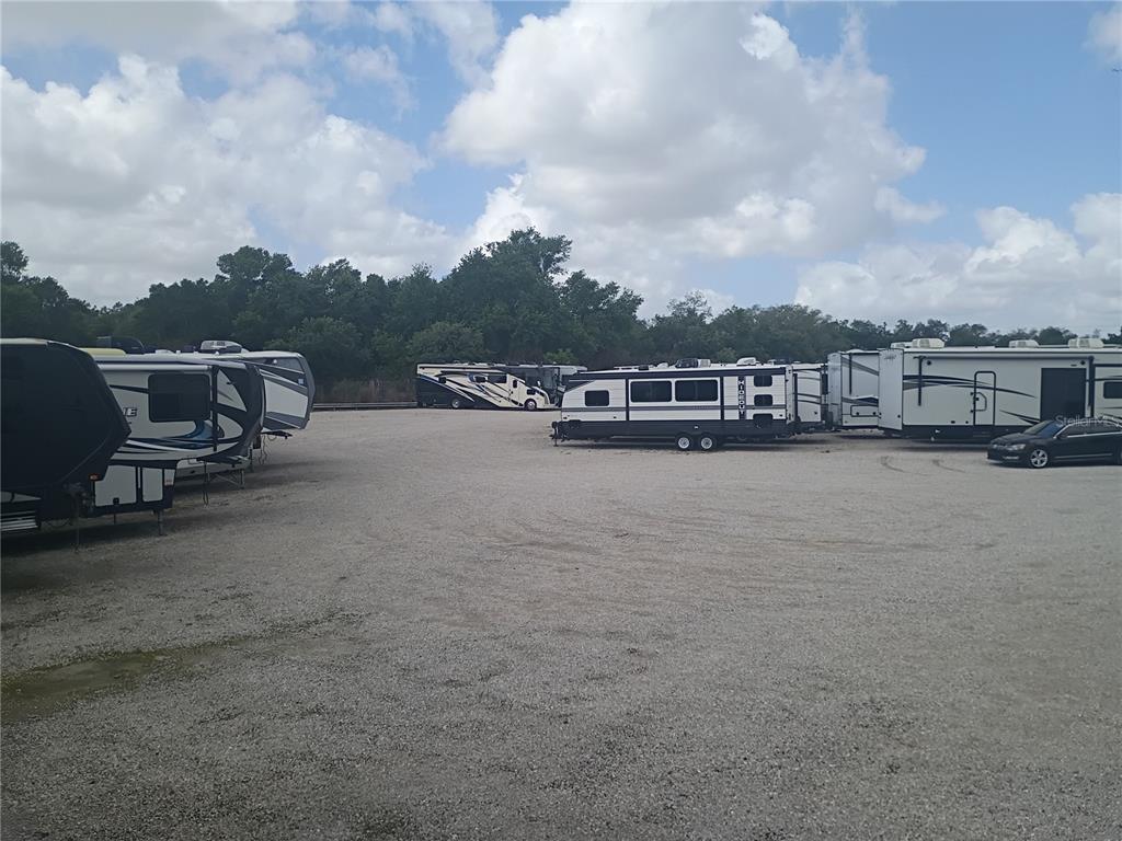 A gravel lot contains several parked recreational vehicles under a cloudy blue sky — 0 STATE ROAD 33 N, LAKELAND, FL