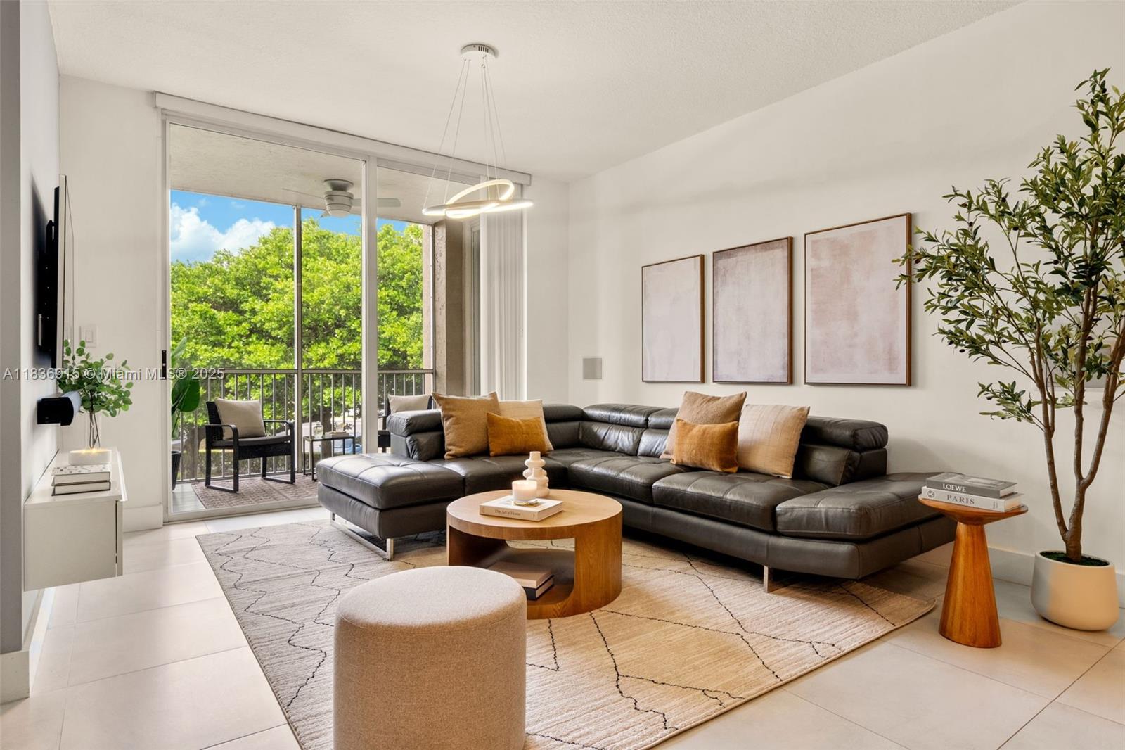 A modern living room features a dark leather sectional, a wooden coffee table, and a balcony — 9755 NW 52nd St # 206, Doral FL 33178, DORAL, FL