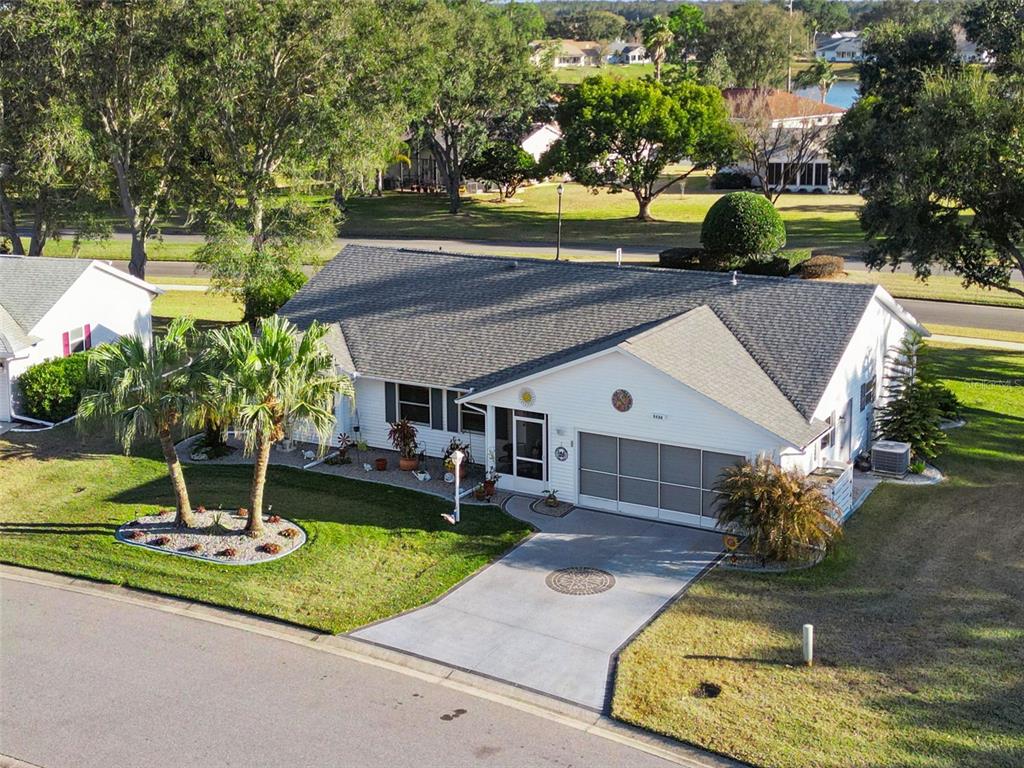 An aerial view of a single-story white house with a gray roof and concrete driveway — 5636 LAVER STREET, LEESBURG, FL