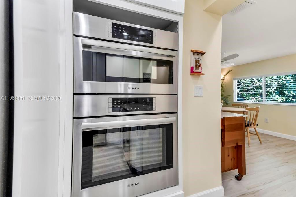 A stainless steel Bosch wall oven and microwave unit are built into a kitchen cabinet — 222 SW 7th St, Dania Beach FL 33004, DANIA BEACH, FL