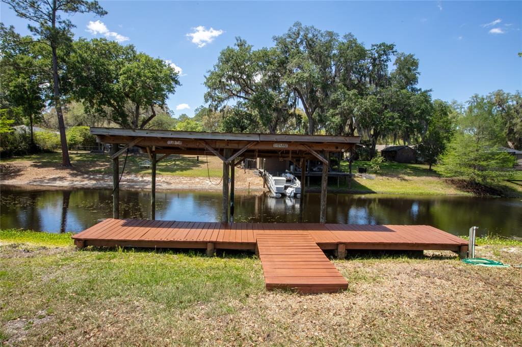 A wooden boat dock with a covered slip sits on the edge of a lake — 5930 ISLAND ROAD, MELROSE, FL