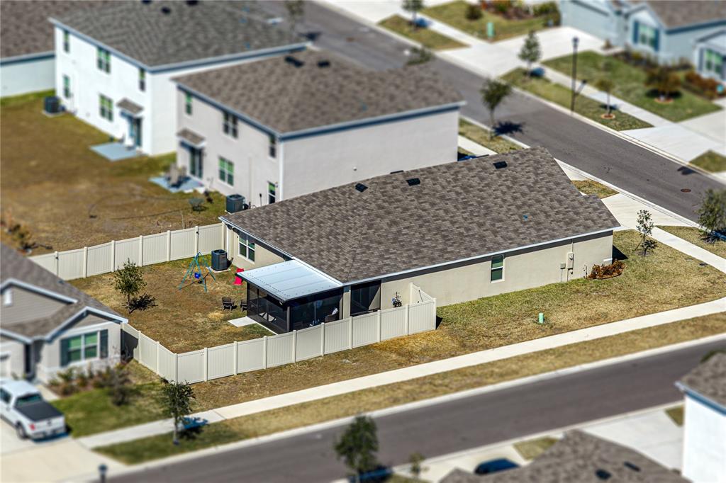 An aerial view shows a single-story house with a fenced backyard and a screened patio — 2741 GARDINER LANE, ZEPHYRHILLS, FL