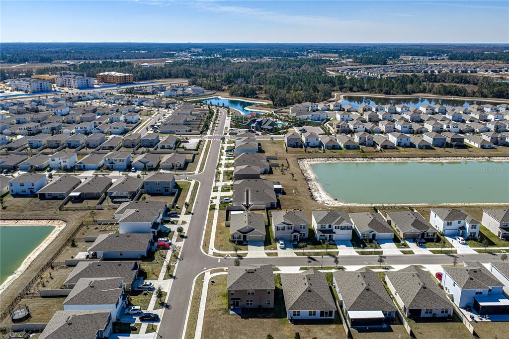 An aerial view shows a suburban neighborhood with houses, streets, and retention ponds — 2741 GARDINER LANE, ZEPHYRHILLS, FL