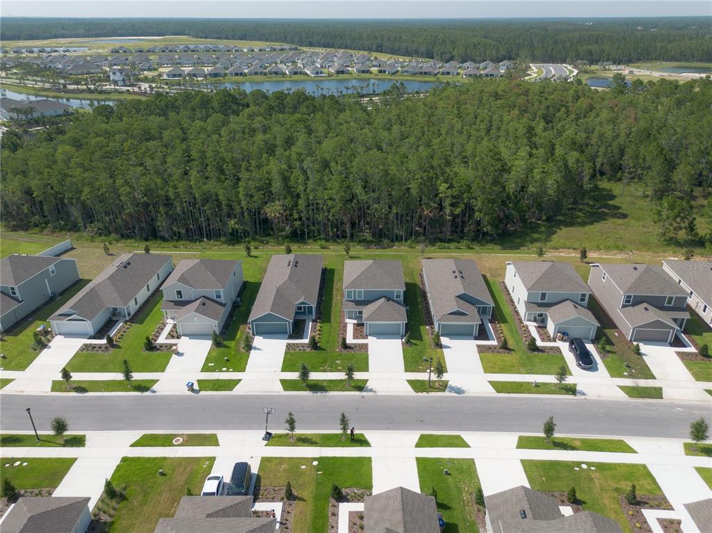 An aerial view shows a row of suburban houses with driveways facing a paved street — 5615 MORANT BAY PATH, KISSIMMEE, FL