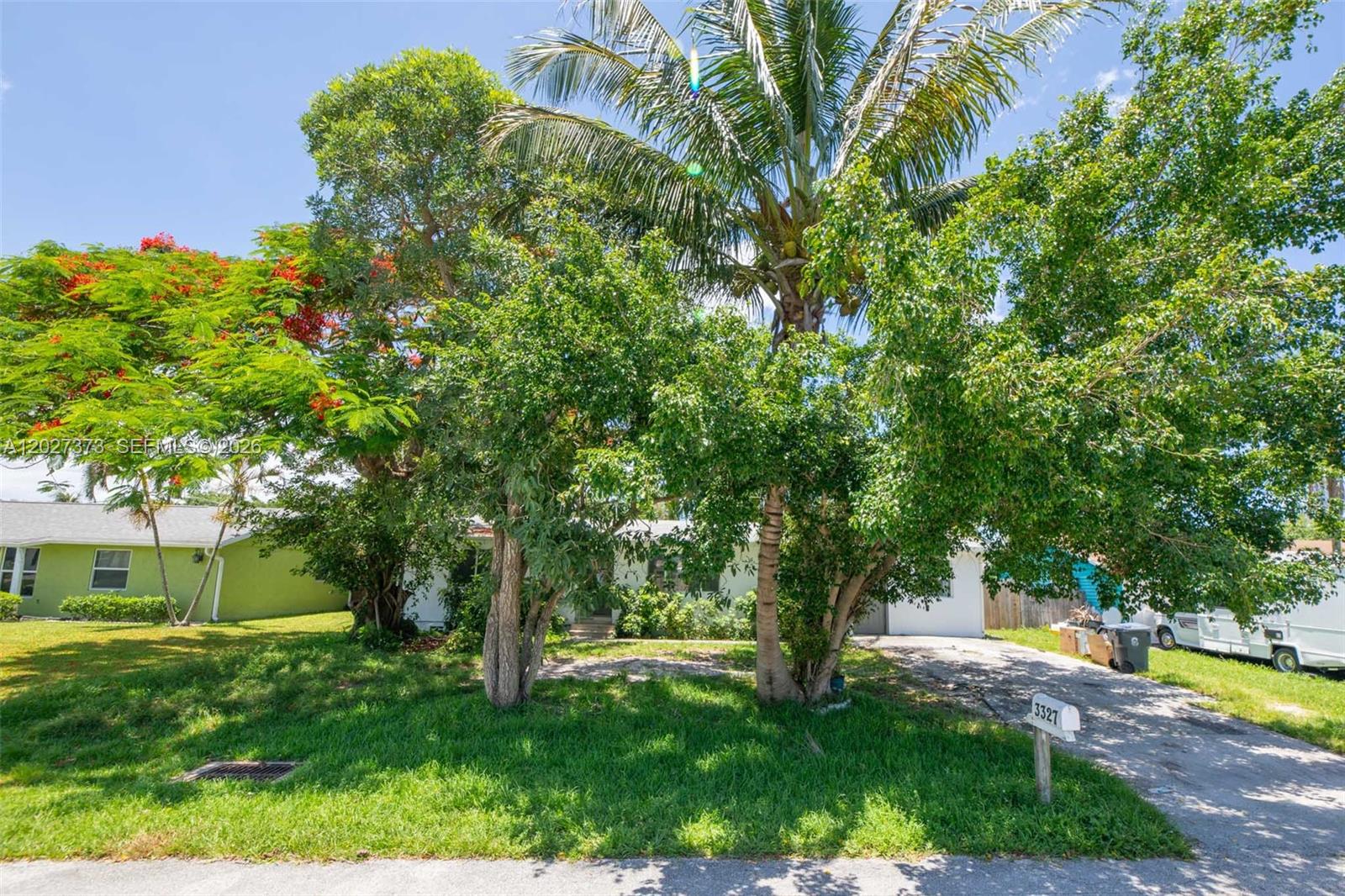 A single-story house is partially obscured by large trees and a palm tree — 3327 Sapphire Rd, Lake Worth FL 33462, LAKE WORTH, FL