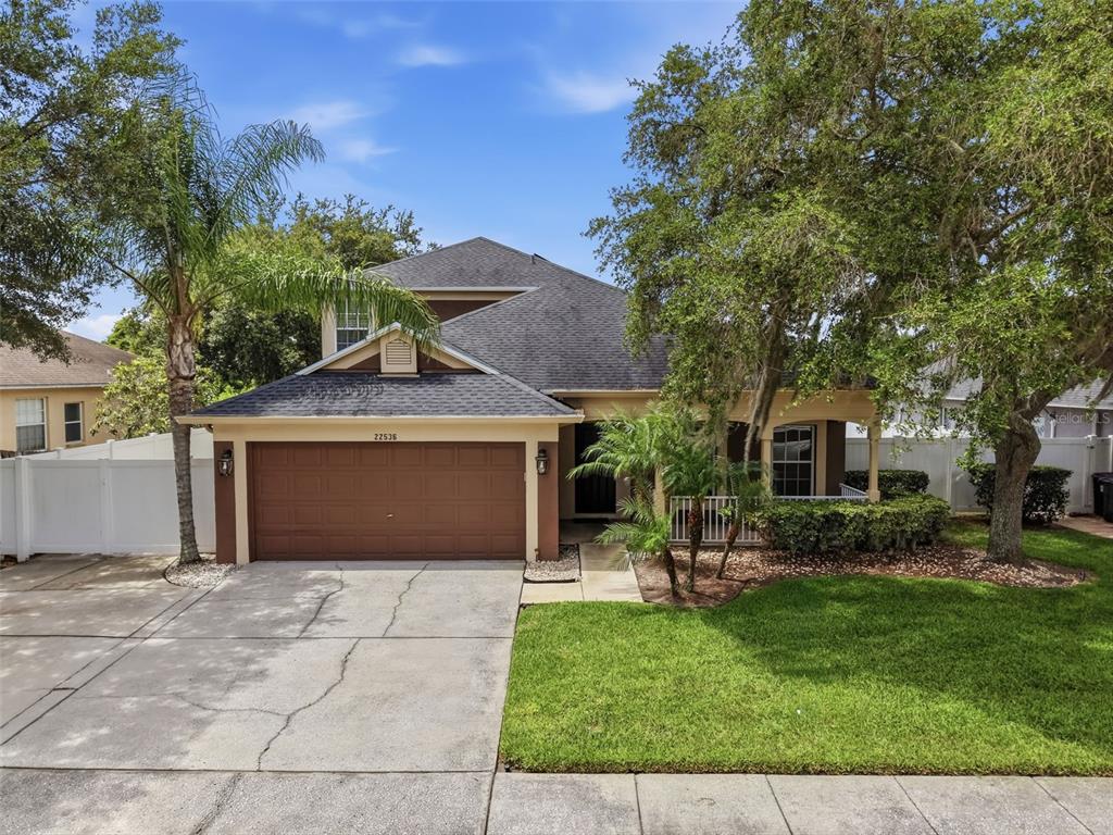 A two-story house with a brown garage, a front porch, and a concrete driveway — 22536 LAURELDALE DRIVE, LUTZ, FL