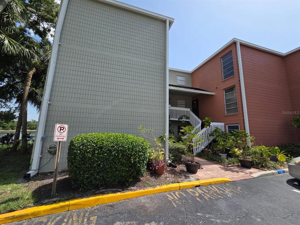An exterior view of a two-story apartment building with green and orange siding — 2424 W TAMPA BAY BOULEVARD UNIT I103, TAMPA, FL