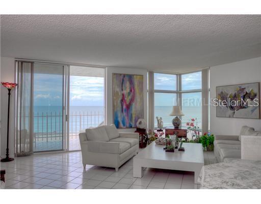 A living room with white tile floors, two sofas, and large windows overlooking the ocean — 2425 GULF OF MEXICO DRIVE UNIT 4E, LONGBOAT KEY, FL