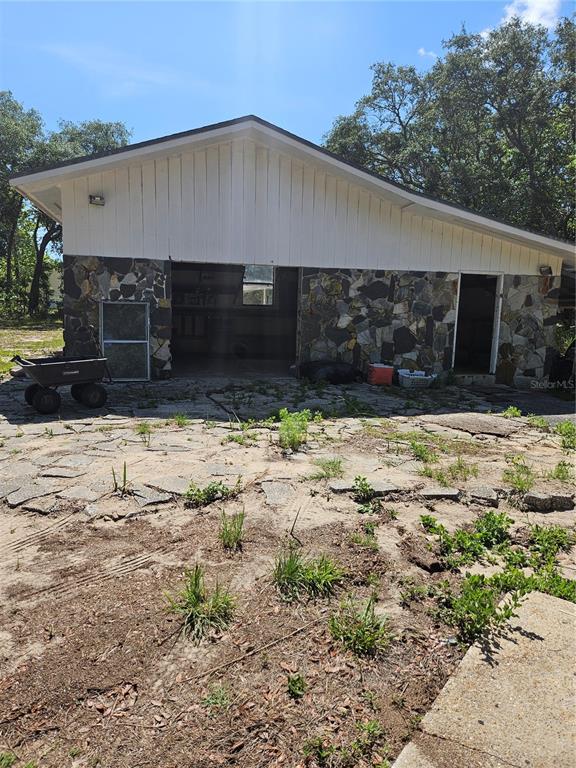 A detached garage with stone siding and a white vertical-board gable sits on a lot — 4300 W ROADRUNNER COURT, HOMOSASSA, FL