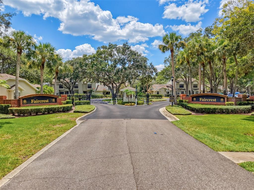The entrance to the Faircrest community features brick signage, palm trees, and a gated driveway — 5100 BURCHETTE ROAD UNIT 905, TAMPA, FL
