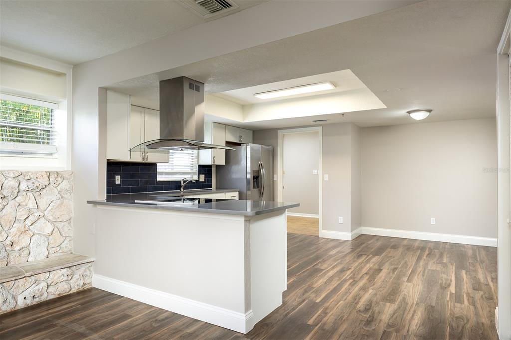 A kitchen with white cabinets, stainless steel appliances, and a stone accent wall — 515 TIVOLI COURT, ALTAMONTE SPRINGS, FL