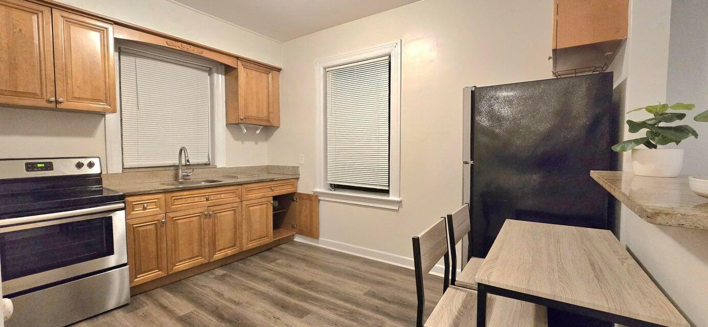 A kitchen features wood cabinets, stainless steel appliances, a dining table, and light-colored walls — 333 Walton Boulevard # 3, West Palm Beach FL 33405, WEST PALM BEACH, FL