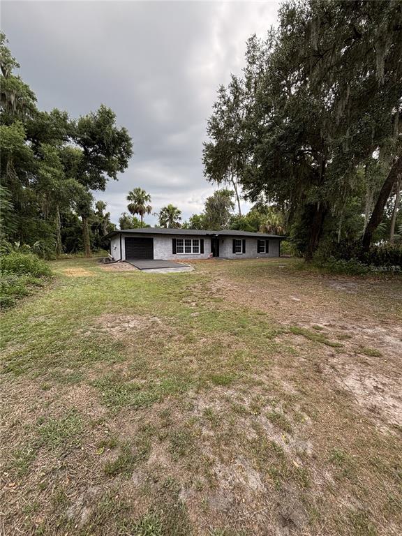 A single-story house with a gray exterior, black shutters, and a garage sits on a lot — 2911 WILLIAMS ROAD, PLANT CITY, FL