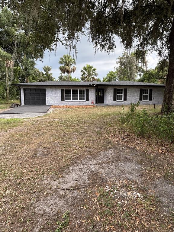 A single-story gray brick house with a black garage door and black window shutters — 2911 WILLIAMS ROAD, PLANT CITY, FL