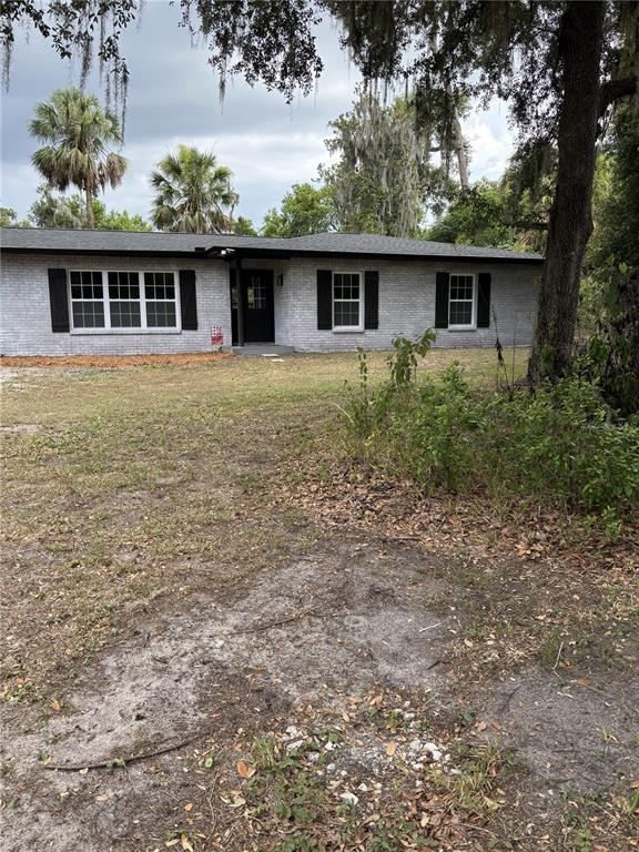 A single-story house with a gray brick exterior, black shutters, and a dark front door — 2911 WILLIAMS ROAD, PLANT CITY, FL