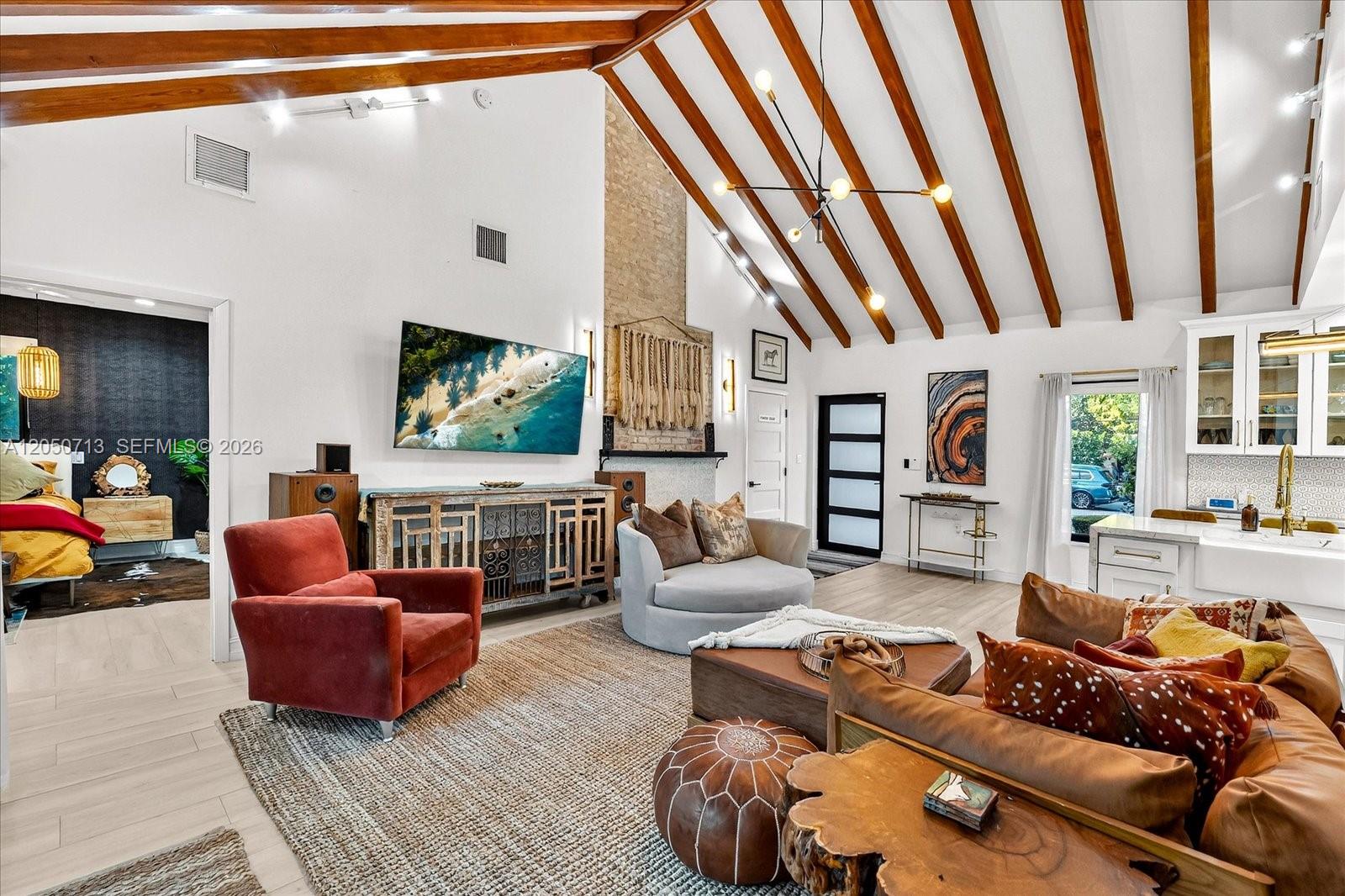 A living room features a vaulted ceiling with exposed wood beams and a brick fireplace — 8225 NE 8th Ct, Miami FL 33138, MIAMI, FL