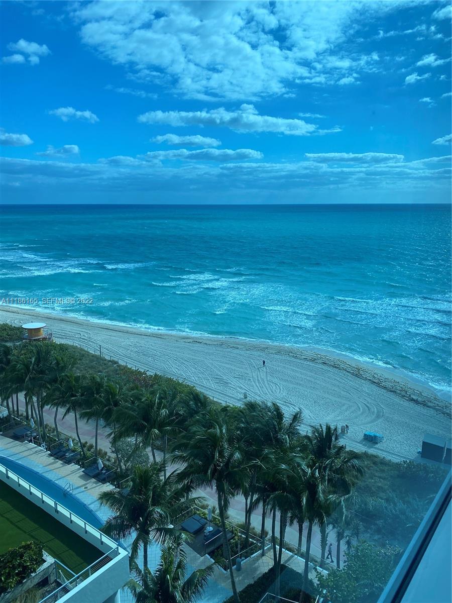 An elevated view of a sandy beach and turquoise ocean from a balcony — 6801 Collins Ave, Miami Beach FL 33141, MIAMI BEACH, FL