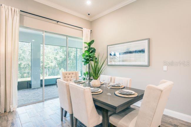 A dining room with a wooden table, upholstered chairs, and a sliding glass door — 2274 BELEN AVENUE, SPRING HILL, FL