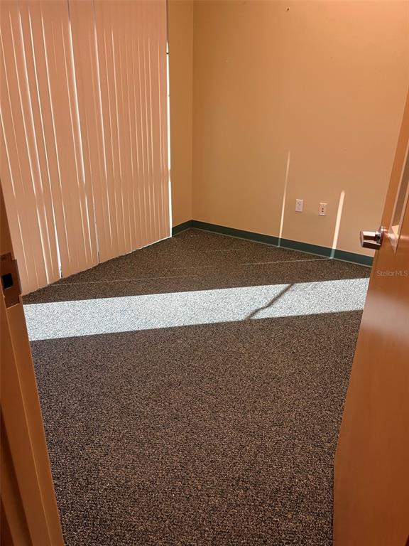 An empty office with beige walls, gray carpet, and vertical blinds over a window — 5999 DUNDEE ROAD UNIT 800, WINTER HAVEN, FL