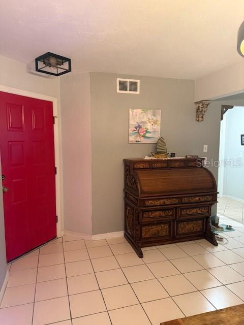 A room with a bright red door, light-colored tile flooring, and a wooden roll-top desk — 823 LONG MEADOW COURT, PORT ORANGE, FL