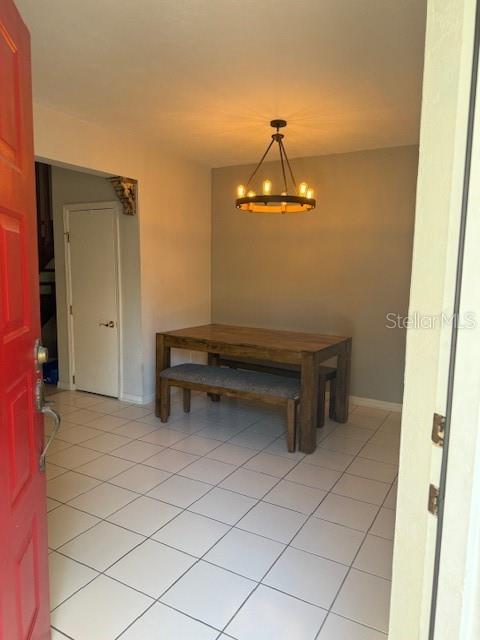 A dining area features a wooden table, a bench, and a circular chandelier on tile floors — 823 LONG MEADOW COURT, PORT ORANGE, FL