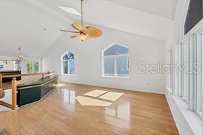 A bright, high-ceilinged living room features light hardwood floors, a ceiling fan, and large windows — 79 TIDY ISLAND BOULEVARD UNIT 79, BRADENTON, FL