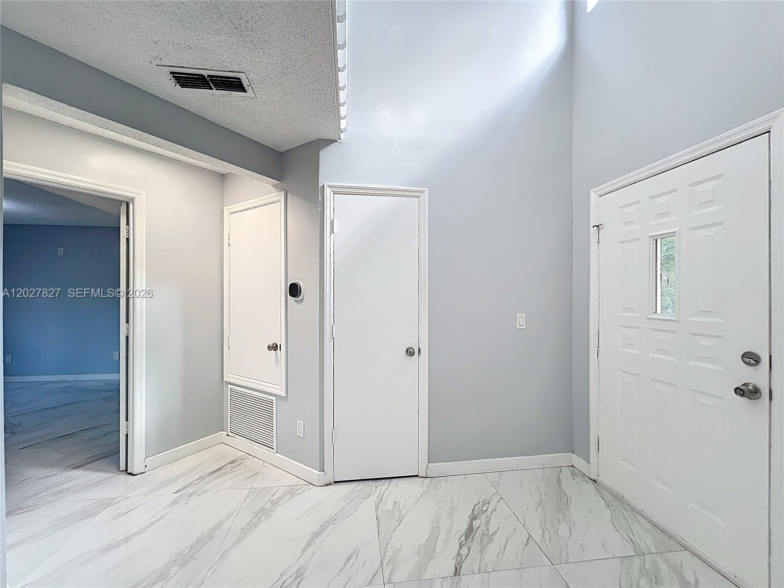 An entryway features white marble-look tile flooring, light gray walls, and three white doors — OTHER CITY - IN THE STATE OF FLORIDA, FL