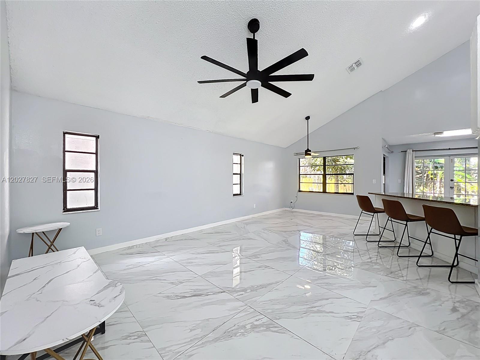 A spacious living area features vaulted ceilings, large marble-look floor tiles, and a breakfast bar — OTHER CITY - IN THE STATE OF FLORIDA, FL