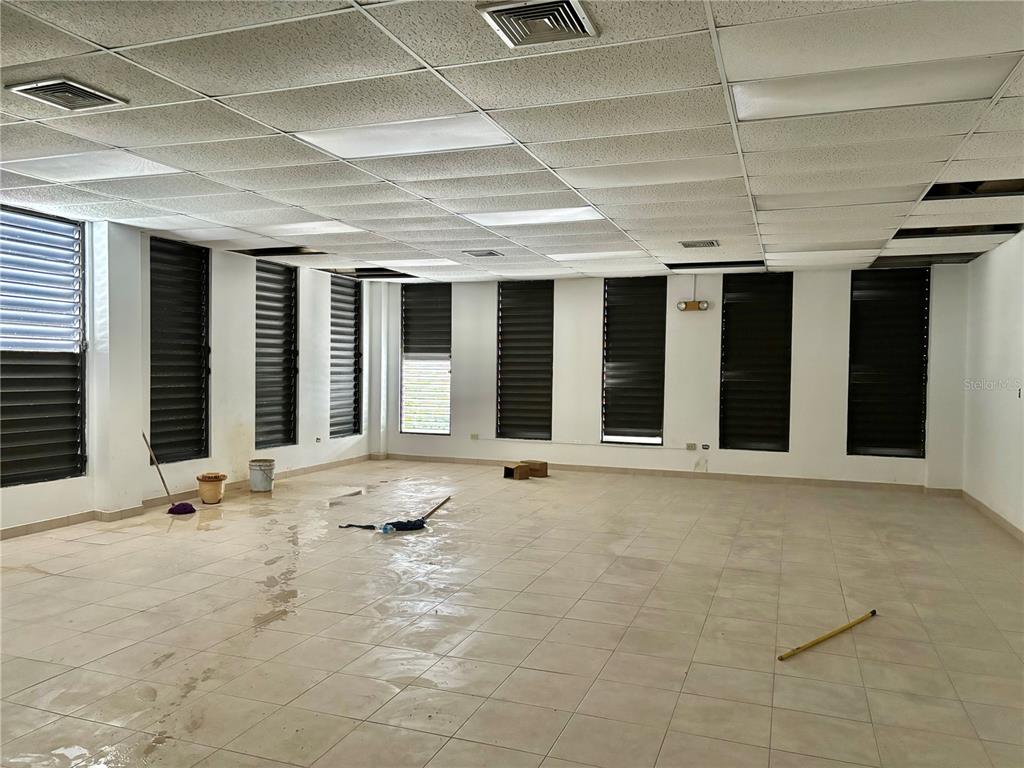An empty commercial room features tiled floors, a drop ceiling, and several louvered windows — 20 LUIS MUNOZ RIVERA, AGUAS BUENAS, PR