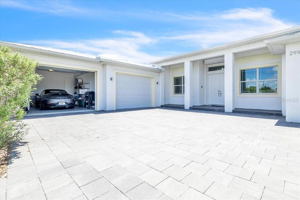A single-story house exterior features a paved driveway, a two-car garage, and white siding — 2918 SE 10TH PLACE, CAPE CORAL, FL