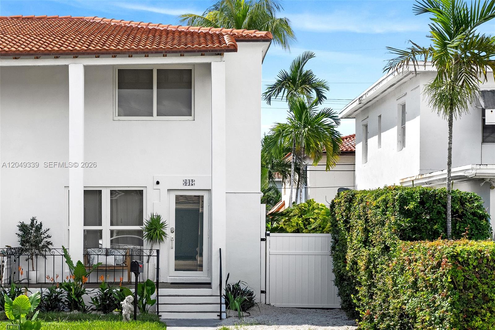 A two-story white stucco building features a tiled roof, a front entrance, and landscaping — 642 86th St, Miami Beach FL 33141, MIAMI BEACH, FL