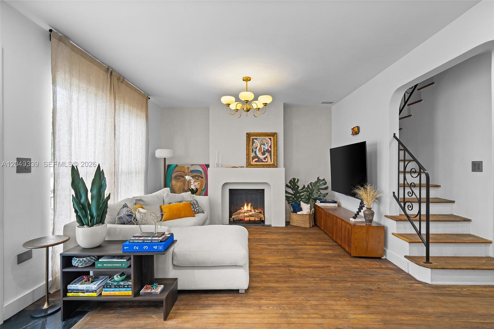 A living room features a fireplace, a sectional sofa, a television, and a staircase — 642 86th St, Miami Beach FL 33141, MIAMI BEACH, FL