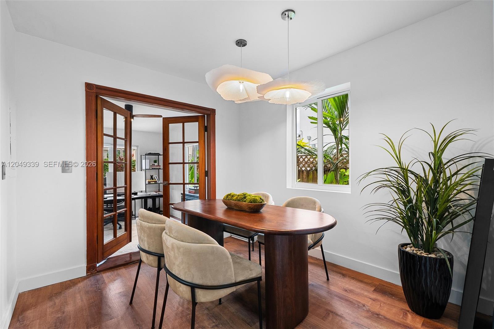 A dining room features a wooden table, four chairs, and two pendant lights — 642 86th St, Miami Beach FL 33141, MIAMI BEACH, FL