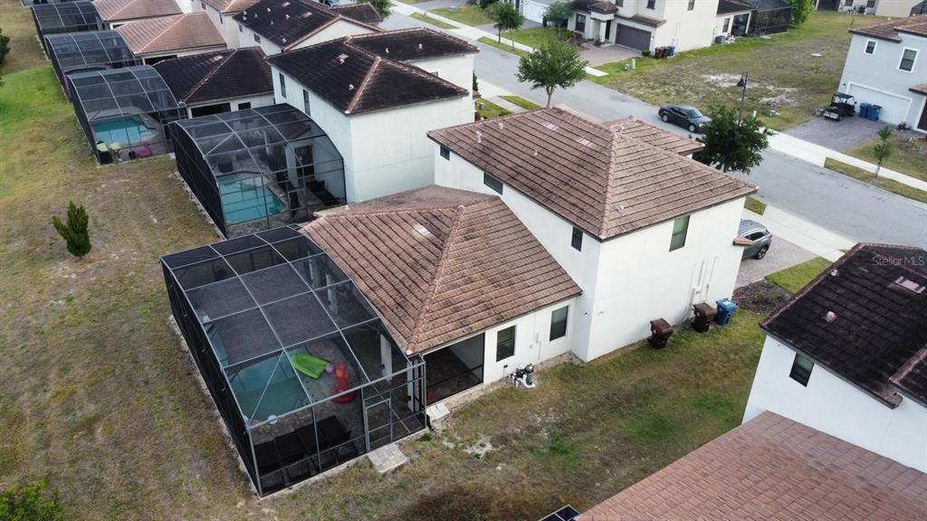 An aerial view shows a two-story house with a screened-in pool and tile roof — 179 MITCHELLS MANOR, HAINES CITY, FL