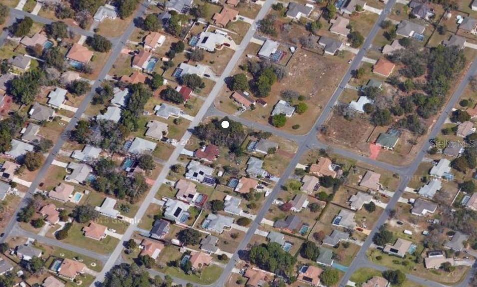 This is an aerial view of a residential neighborhood with houses and streets — 11416 ADELIA STREET, SPRING HILL, FL