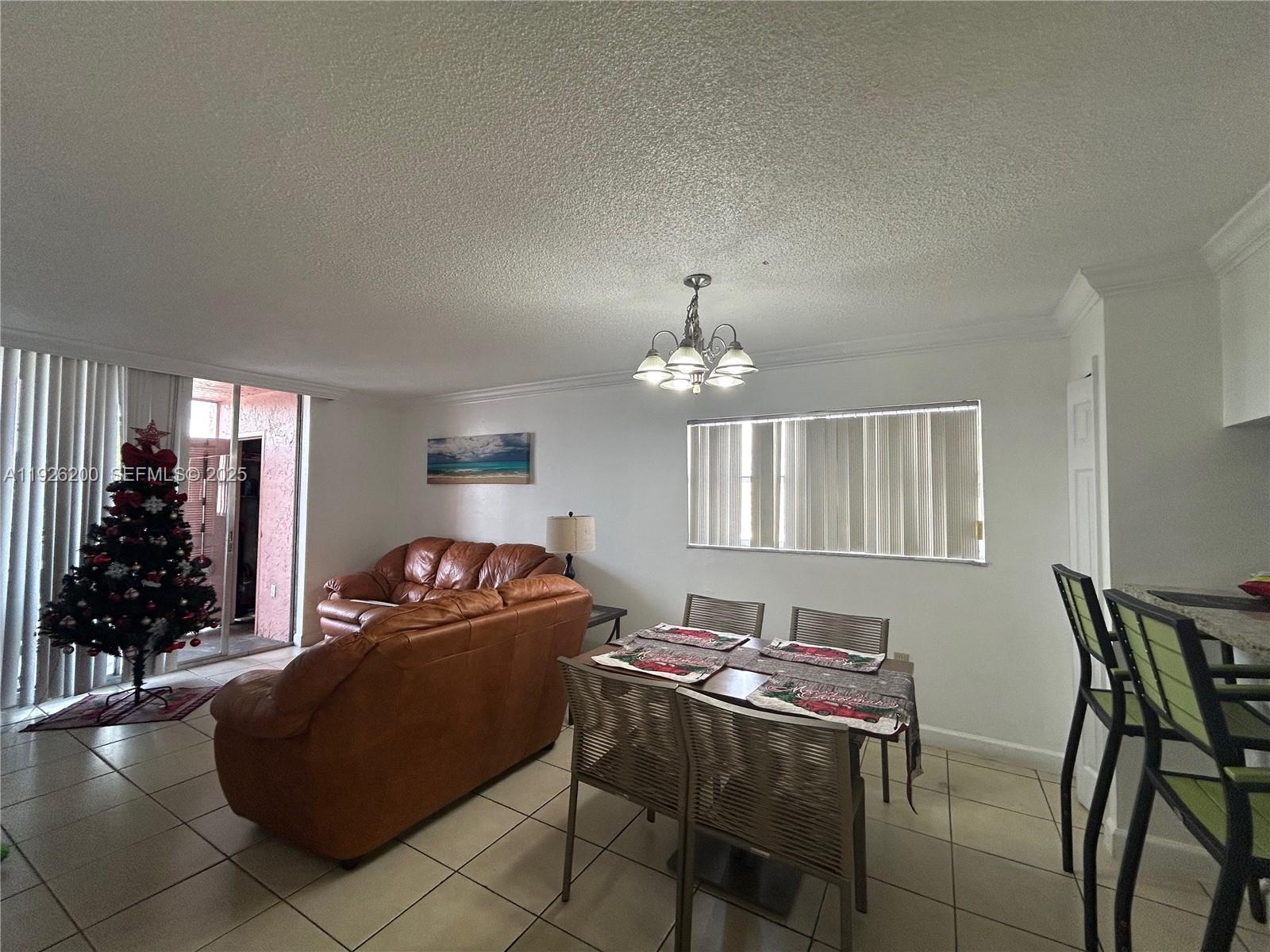 A living and dining area features tile flooring, a leather sofa, and a Christmas tree — 19805 SW 114th Ave # 219, Miami FL 33157, MIAMI, FL