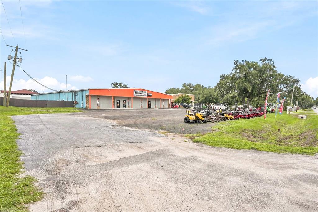 An exterior view of a commercial building with a gravel lot displaying several lawn mowers — 13295 92 HIGHWAY, DOVER, FL