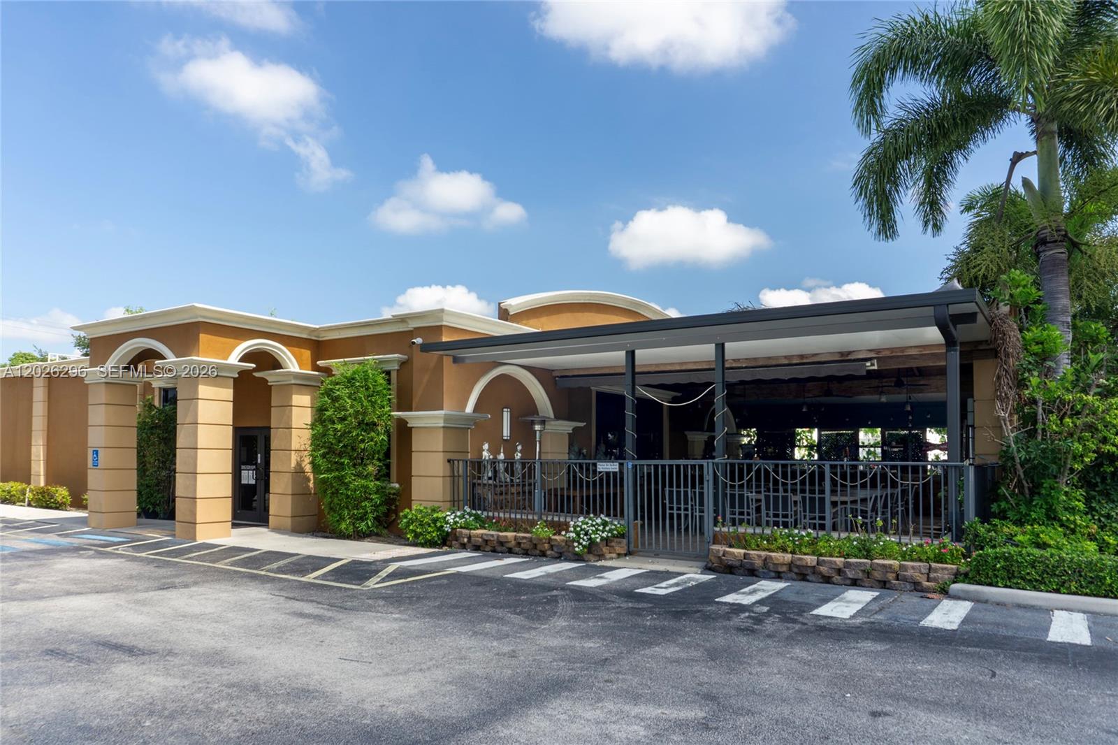 A tan commercial building features a covered outdoor patio area with metal fencing — 1785 N State Road 7, Margate FL 33063, MARGATE, FL