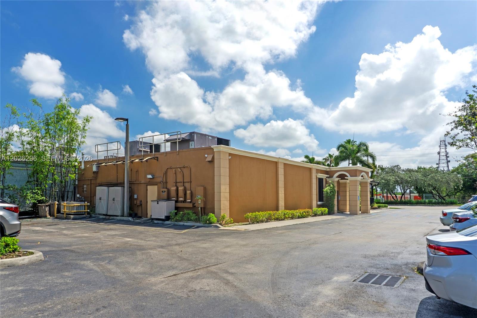 The exterior of a tan commercial building features a parking lot and a blue sky — 1785 N State Road 7, Margate FL 33063, MARGATE, FL