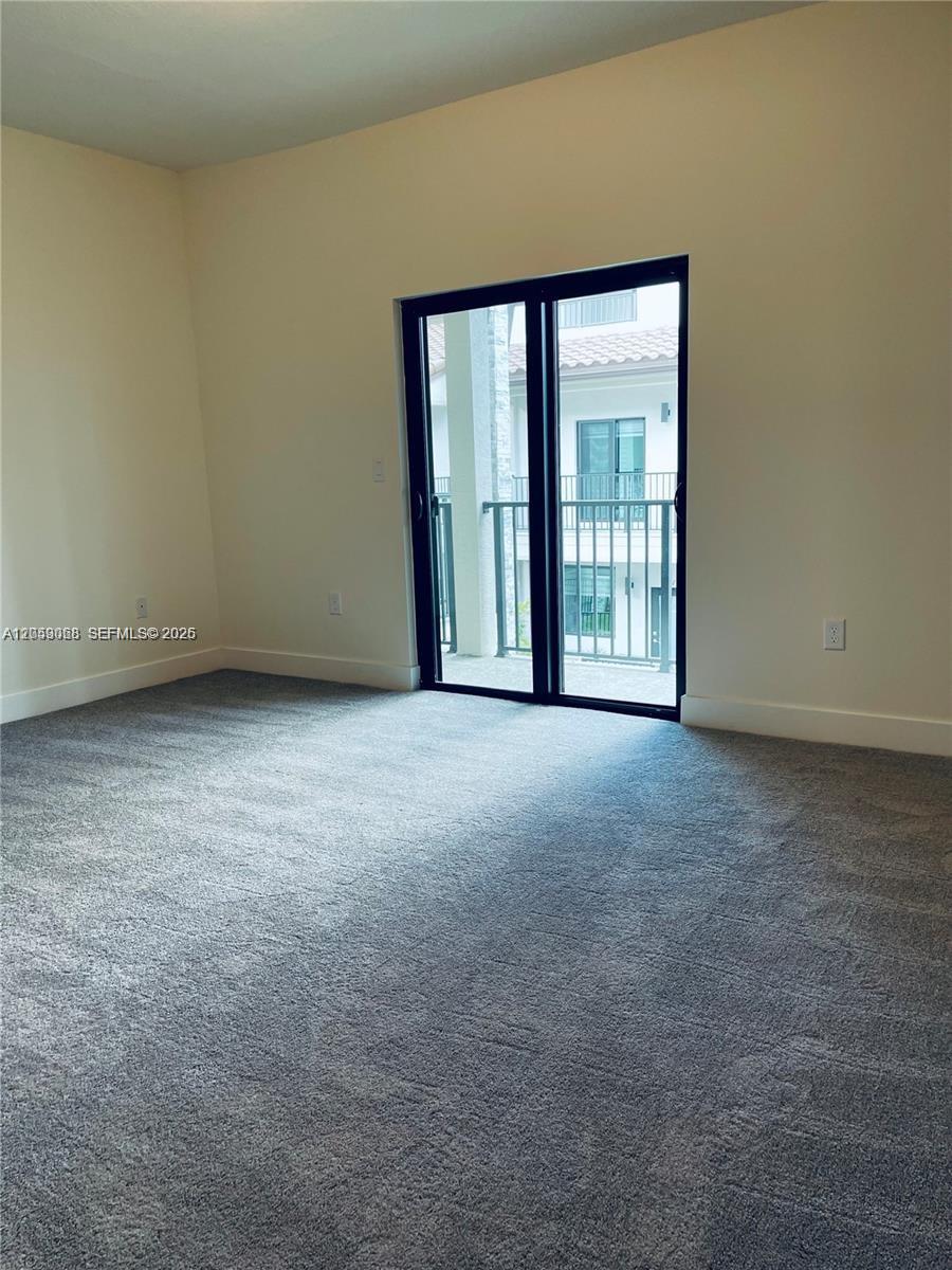 A carpeted bedroom features a sliding glass door leading to a balcony — 4576 NW 83rd Path, Doral FL 33166, DORAL, FL