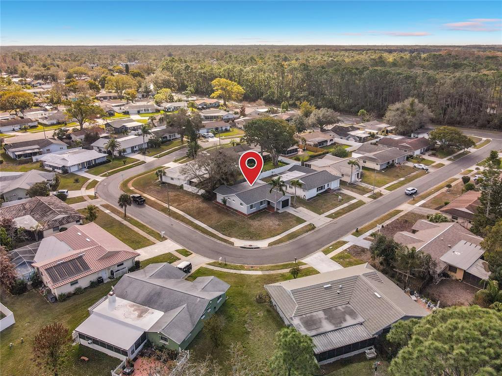 An aerial view shows a single-story house with a red location pin on a corner lot — 819 HELMSMAN WAY, PALM HARBOR, FL