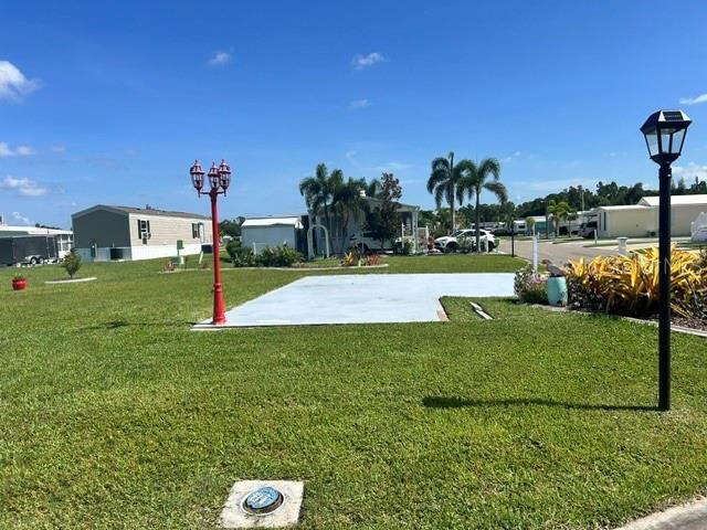A vacant concrete pad sits in a grassy yard between two lamp posts — 267 DOLPHIN PKWY, PUNTA GORDA, FL