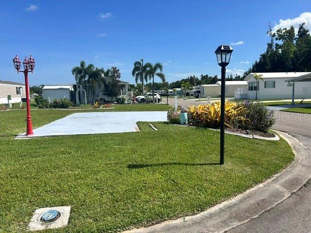 A concrete pad sits in a grassy yard featuring two lamp posts and palm trees — 267 DOLPHIN PKWY, PUNTA GORDA, FL