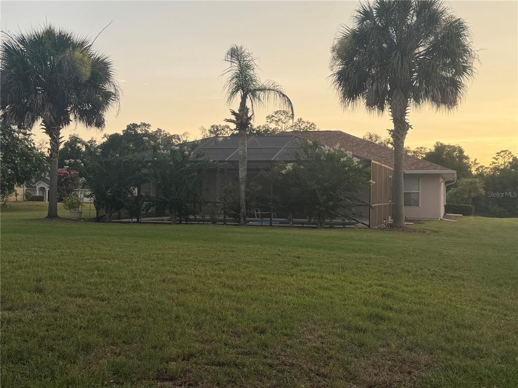 A single-story tan house with a hip roof, arched entryway, and a manicured front lawn — 4025 NE 14TH COURT, OCALA, FL