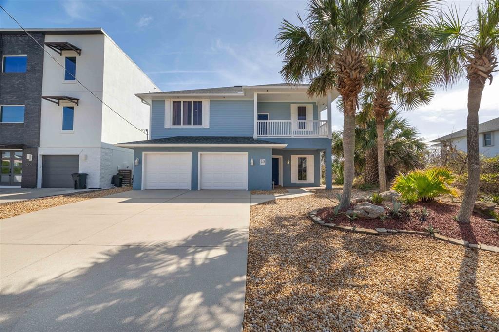 A two-story blue house with a two-car garage and a front balcony — 2708 S OCEAN SHORE BOULEVARD, FLAGLER BEACH, FL