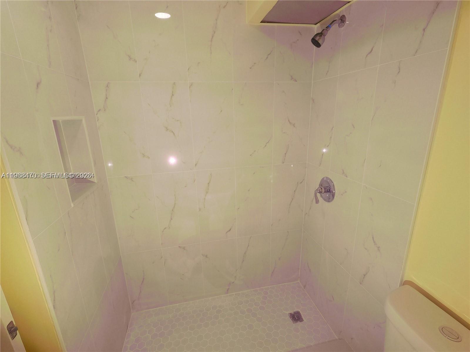 A walk-in shower features white marble-look wall tiles, a hexagonal floor, and a recessed niche — 644 NW 13th St # 0120, Boca Raton FL 33486, BOCA RATON, FL