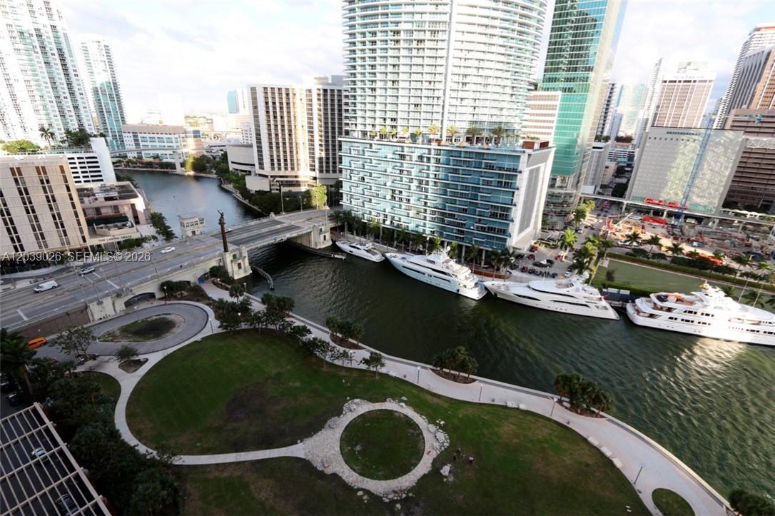 An elevated view of a waterfront park, a bridge, and several yachts docked near skyscrapers — 465 Brickell Ave # 4706, Miami FL 33131, MIAMI, FL