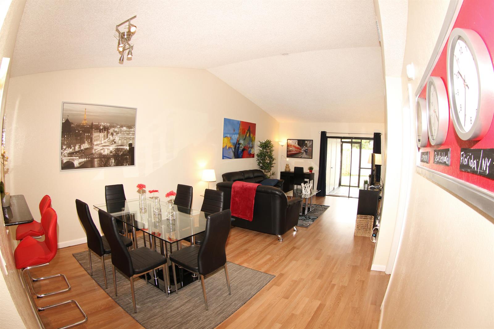 An open-concept living and dining area features wood flooring, a glass table, and modern decor — 1308 White Pine Drive, Wellington FL 33414, WELLINGTON, FL