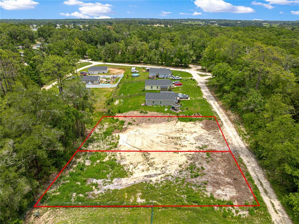 An aerial view shows two adjacent, cleared rectangular lots bordered by trees and a dirt road — SW 41ST STREET ROAD, OCALA, FL